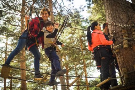 A family enjoys a thrilling day on a ropes course in Cercedilla, Spain.