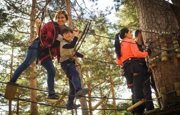 A family enjoys a thrilling day on a ropes course in Cercedilla, Spain.