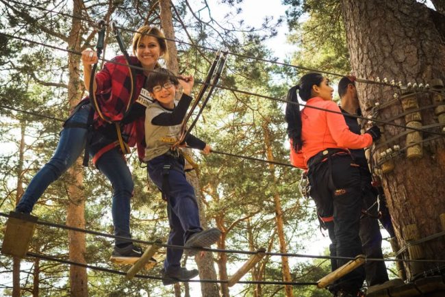 A family enjoys a thrilling day on a ropes course in Cercedilla, Spain.